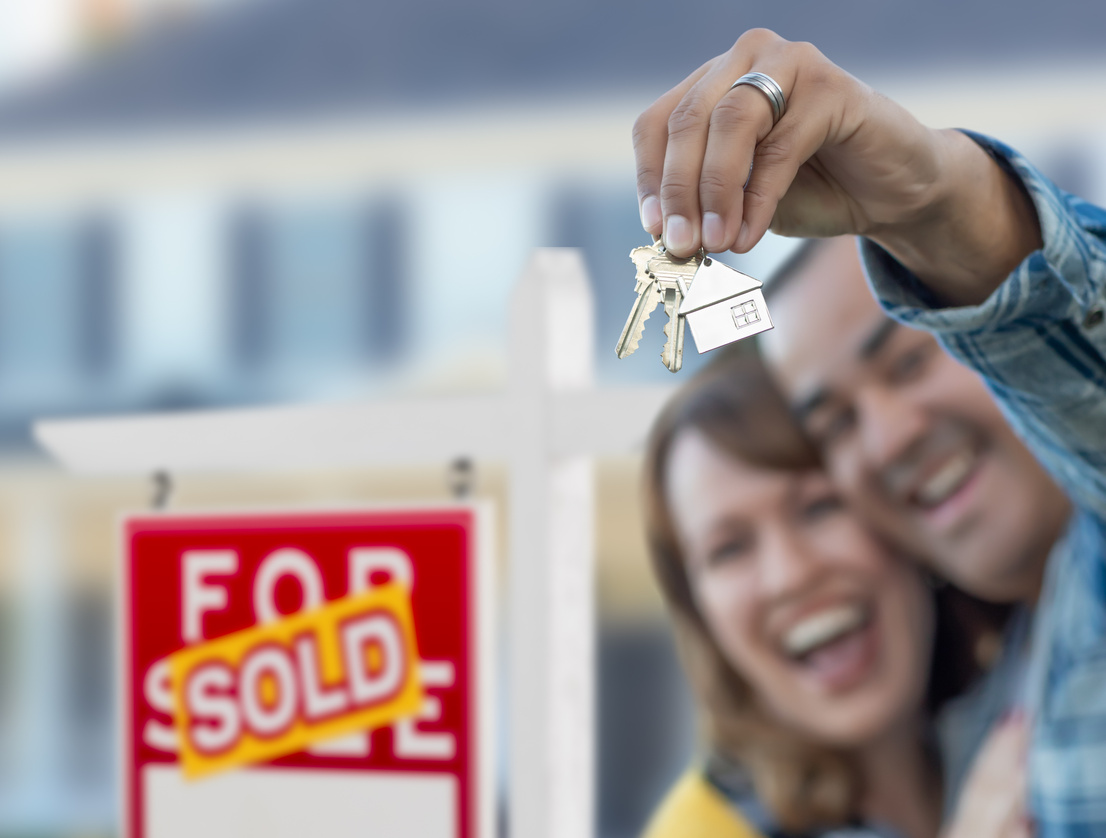 Couple Holding Sold Real Estate Keys Up Close